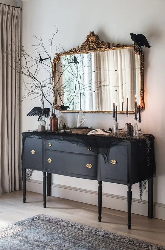 a beautiful black credenza decorated with black spider web, blackbirds, black candles and black branches is amazing
