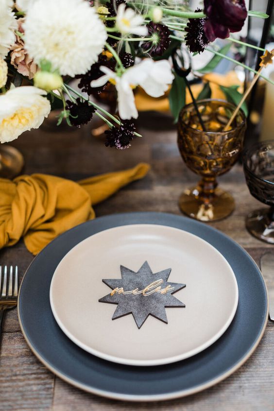 a chic celestial Halloween table setting with a star-shaped card and dark glasses, bold blooms is amazing