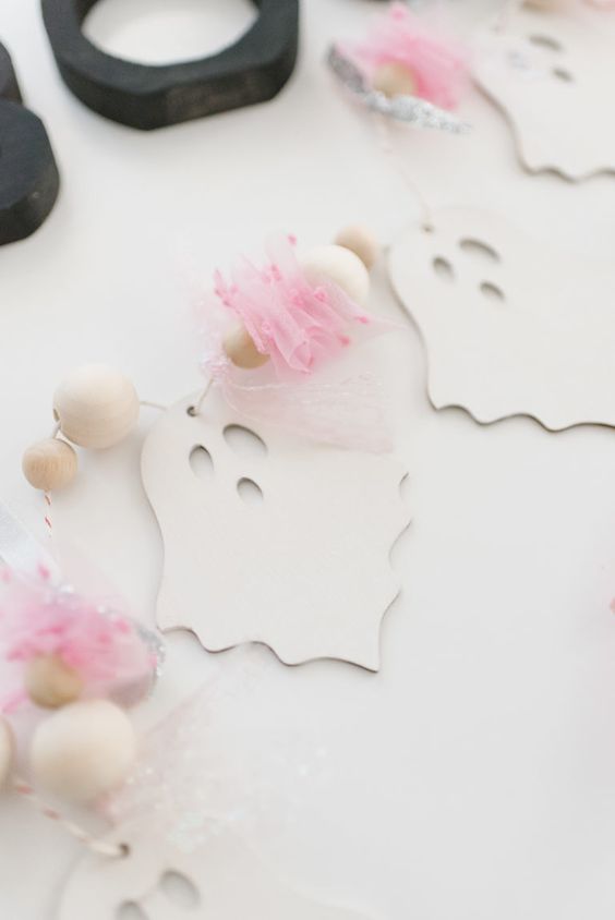 a Halloween ghost garland of wooden beads and pink tulle is a cool solution for styling a fun Halloween space