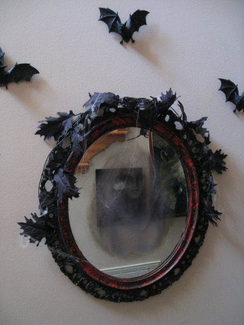 a Halloween mirror with a ghost inside, black leaves and black bats around are a great combo to rock