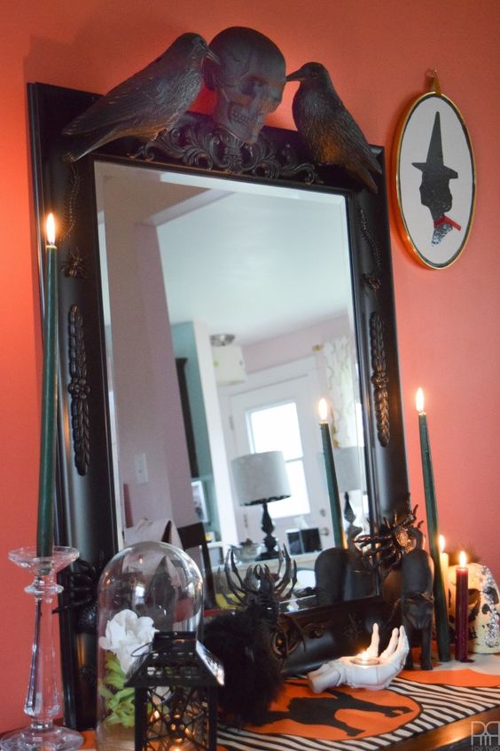 a mirror in a black frame with a skull and blackbirds on top is a cool and bold idea for Halloween