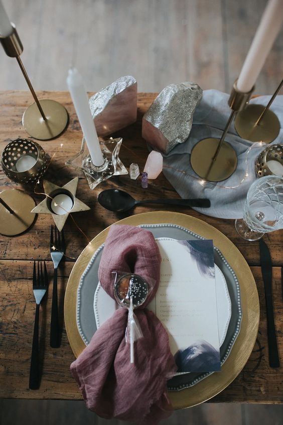 celestial Halloween decor with star-shaped candleholders, rocks, a mauve napkin and a shiny lollipop plus lights