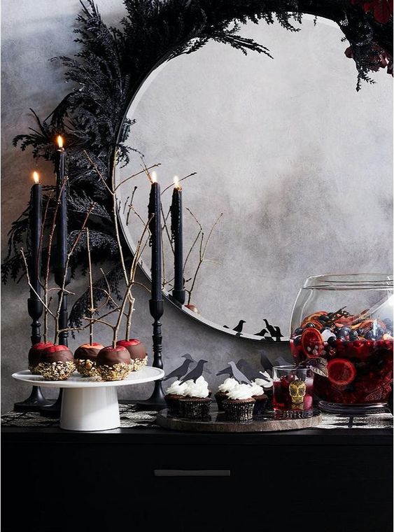a round mirror decorated with black dried leaves is a gorgeous and non-typical solution that can be DIYed fast