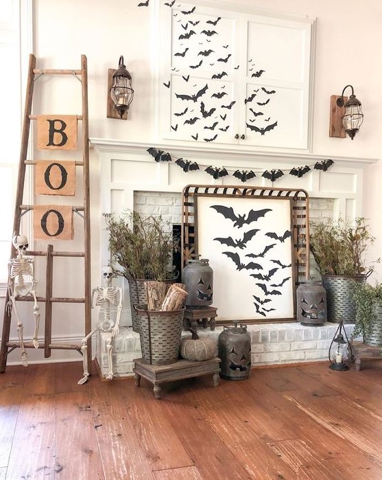 a rustic Halloween mantel with lots of bats, dried branches, jack-o-lanterns, skeletons, a ladder with letters