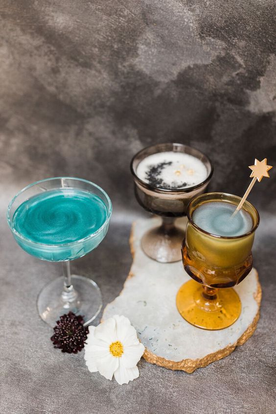 lovely Halloween celestial cocktails in turquoise color, with a moon and star-shaped stirrers