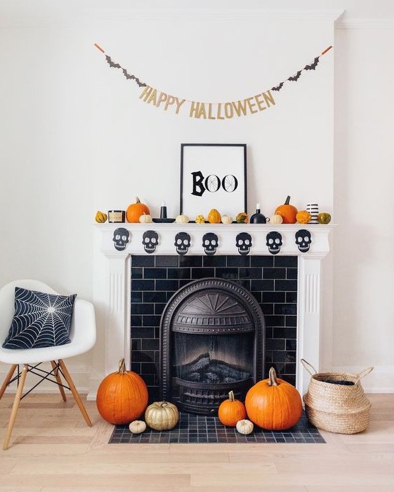 fun and bright Halloween mantel decor with gourds and pumpkins, candles, a banner and a chic sign, pumpkins on the floor