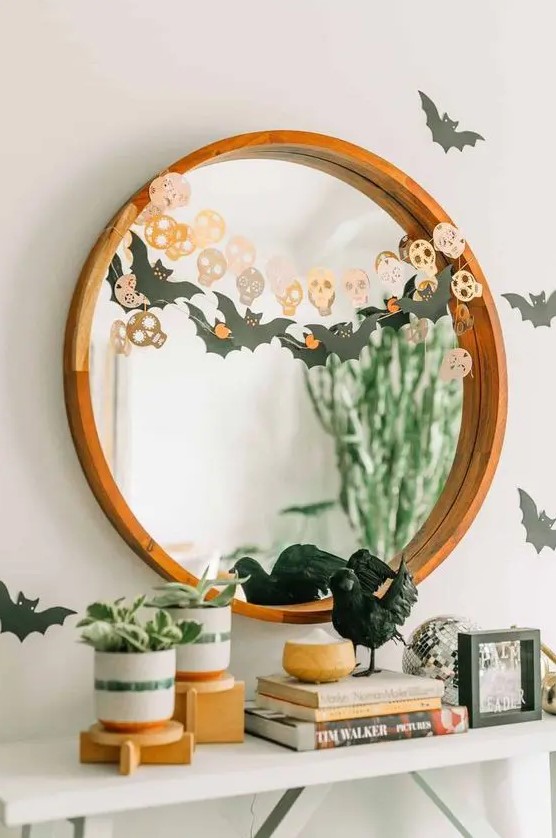 simple and quick Halloween mirror decor with a bat and a skull garland is a cool last-minute solution