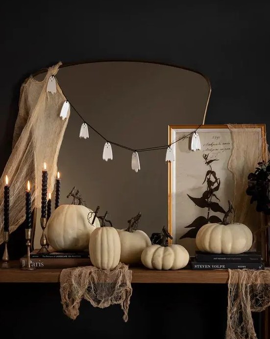 simple Halloween mirror decor with some cheesecloth and a ghost garland is a cool and fast to realize idea