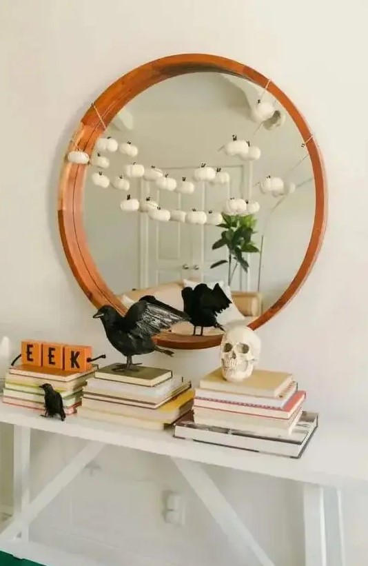 stylish minimalist Halloween decor with blackbirds, a skull and a garland of mini white pumpkins is very chic and cool