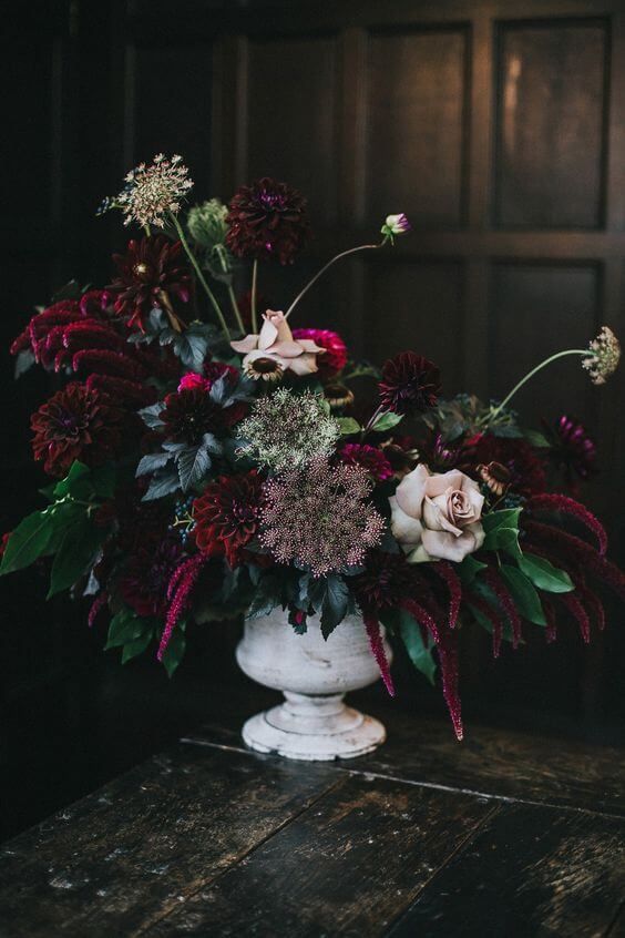 a Halloween flower arrangement of blush roses, burgundy dahlias, amaranthus, greenery and seed pods