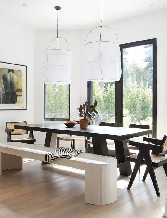 a bold dining zone with a view, a dark stained dining table and chairs, a whitewashed bench and a light-stained floor