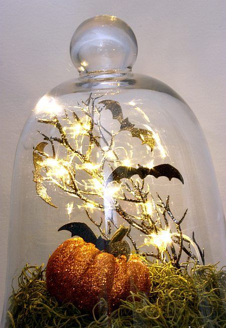 a bright Halloween cloche with moss, a glitter pumpkin, branches, bats is easy to make, it's a cooland simple decoration
