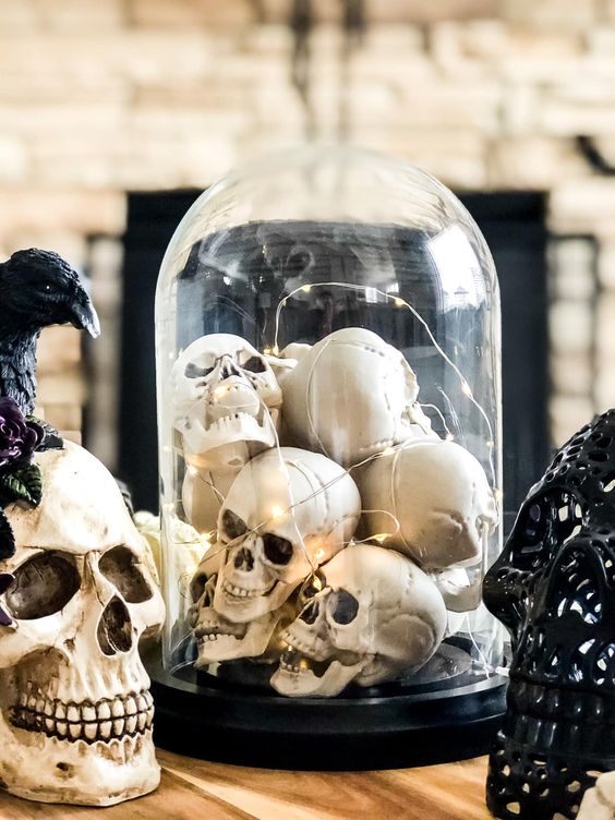 a classic Halloween decoration of a cloche with skulls and lights is a cool and bold solution, and you can make it very fast