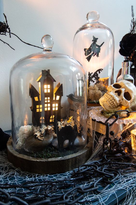 a cloche with a haunted house, a black cat, some rocks and moss is a cool idea for Halloween decor