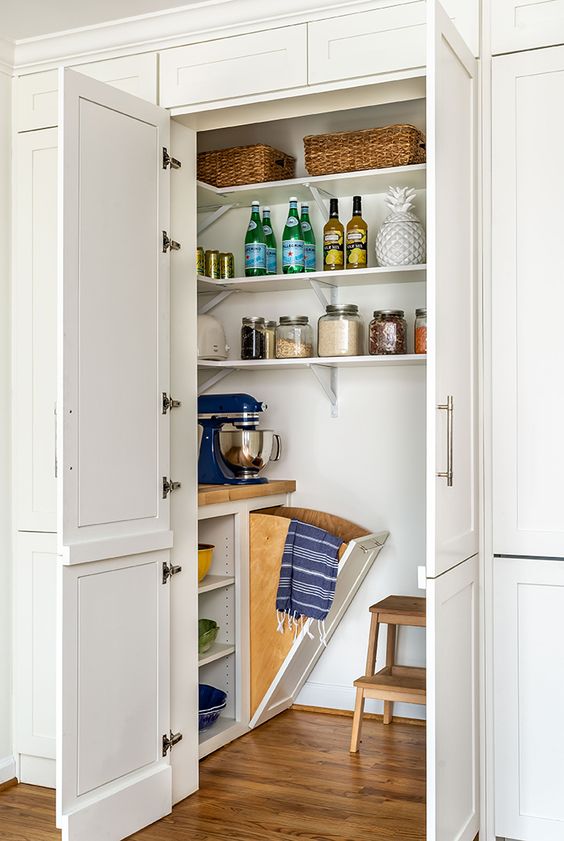 https://www.digsdigs.com/photos/2023/09/a-cool-small-pantry-with-corner-shelves-a-built-in-open-storage-unit-a-stool-and-some-cookware-and-appliances.jpg