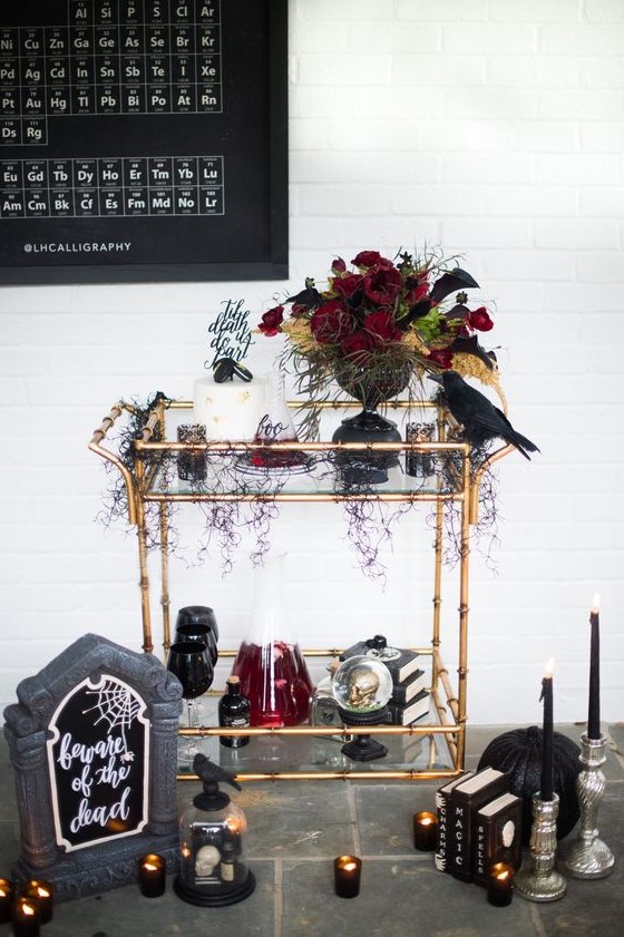 a dark Halloween centerpiece of red, black blooms, dark foliage and bright yellow touches