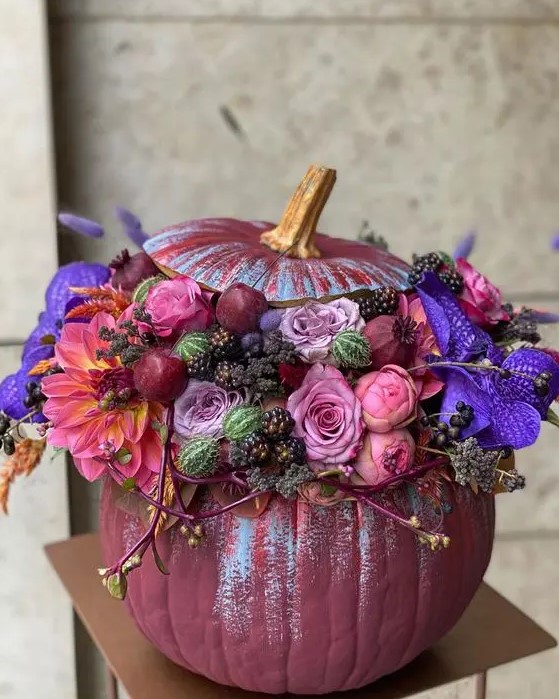 a jaw-dropping purple Halloween pumpkin with pink, mauve and violet blooms, berries and cherries is a chic idea