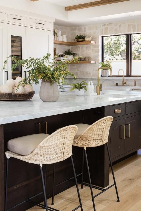 a neutral kitchen with white shaker cabinets, a stone backsplash and open shelves, a dark-stained kitchen island with a stone countertop