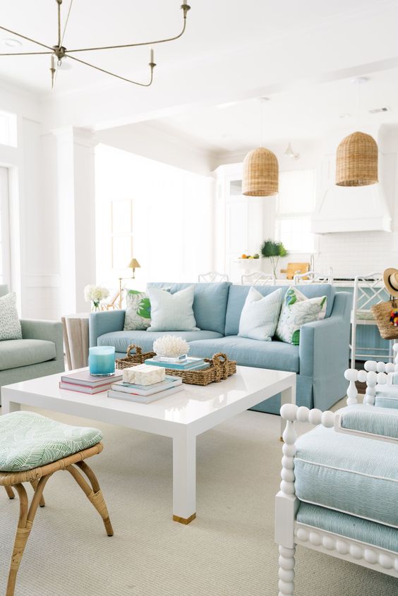 a new traditional coastal living room with a blue sofa, mint blue chairs, mint green stools, a coffee table