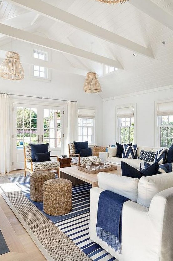 a preppy coastal living room with rattan lampshades, jute ottomans, stripes and traditional furniture