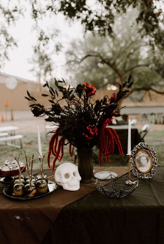 a refined Halloween floral arrangement with black adn red blooms and black painted bunny tails