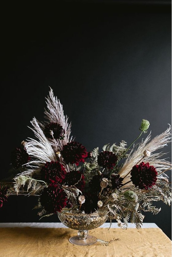 a refined Halloween floral arrangement with dark dahlias, dried blooms, leaves and grasses is a very stylish idea