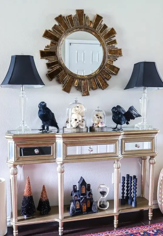 a refined entryway console with black lamps, blackbirds, black candleholders, a black house and Halloween trees
