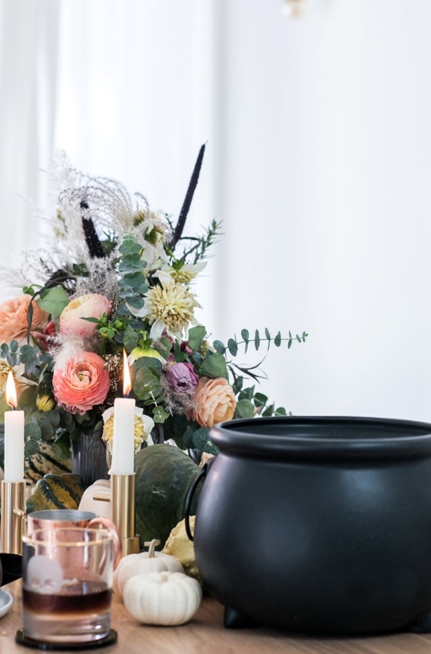 a refined floral Halloween centerpiece with peachy and pink blooms, dried blooms and grasses and much eucalyptus