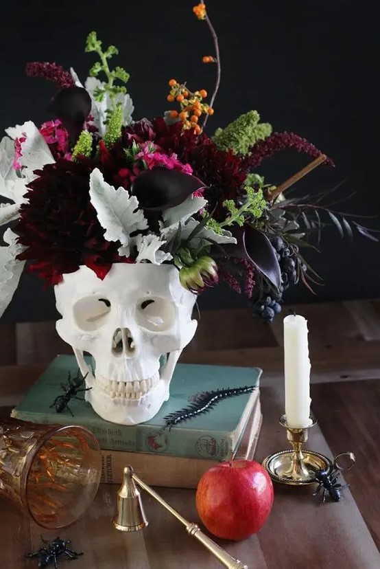 a skull vase with dark dahlias, callas, greenery, berries and some dark foliage is a stunning Halloween centerpiece