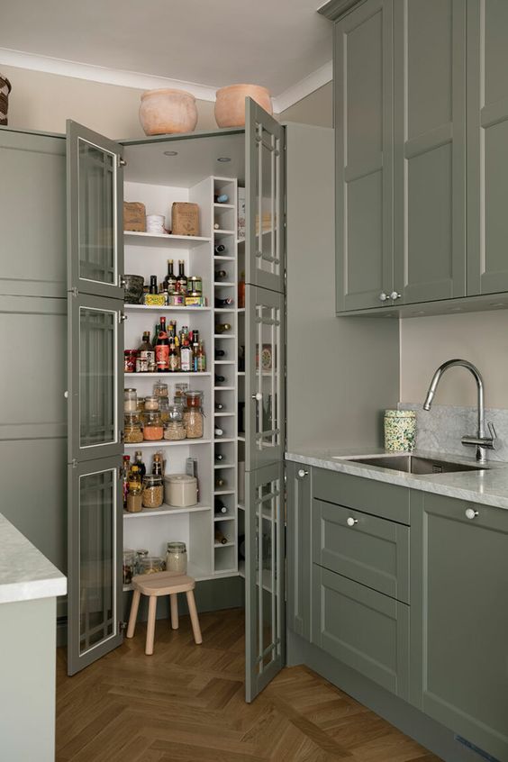 https://www.digsdigs.com/photos/2023/09/a-small-pantry-perfectly-blending-with-the-kitchen-with-built-in-shelves-and-wine-storage-plus-a-small-stool-is-a-smart-idea.jpg