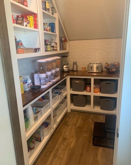 https://www.digsdigs.com/photos/2023/09/a-smart-staircase-pantry-with-a-built-in-storage-unit-with-shelves-and-more-shelves-over-it-with-cubbies-and-all-the-necessary-stuff-here.jpg
