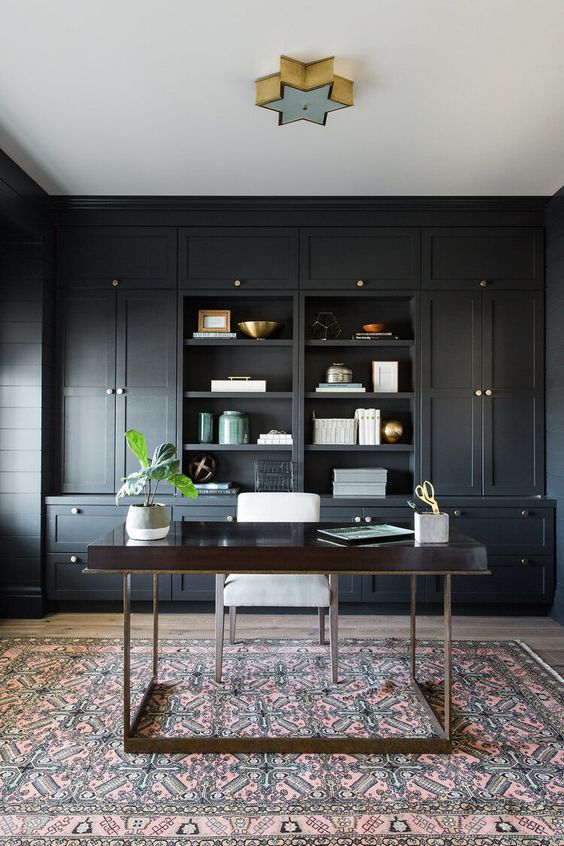 a soot farmhouse home office with built-in cabinetry, a dark-stained vanity and a white chair, a star-shaped lamp