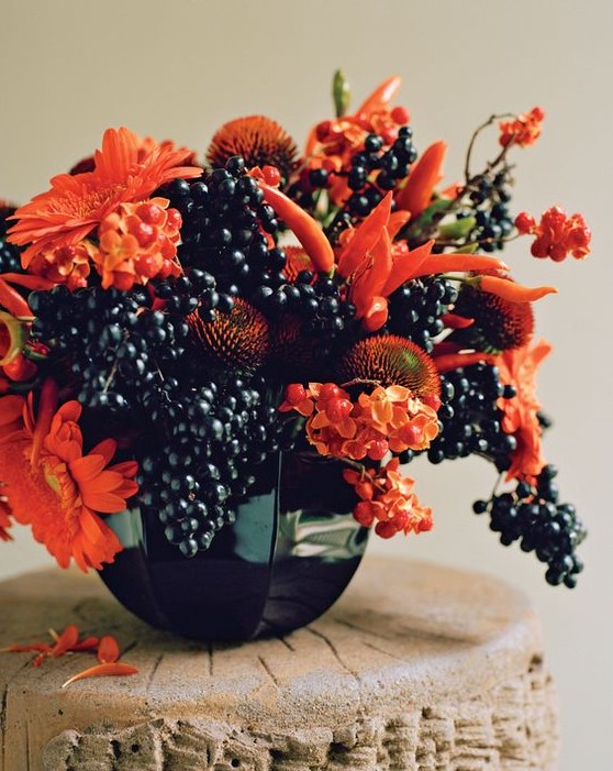 a very sumptuous floral arrangement for Halloween of orange blooms, berries and peppers looks fantastic