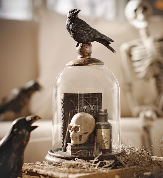 a vintage Halloween cloche with books, a skull, a poison bottle and a blackbird on top is a cool decoration to make yourself