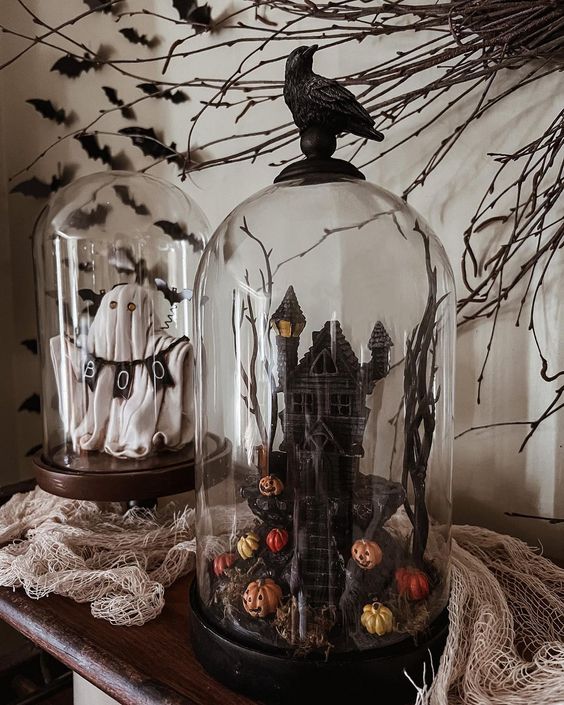 classy Halloween cloches with a ghost and a banner, a castle with pumpkins and branches and a blackbird on top