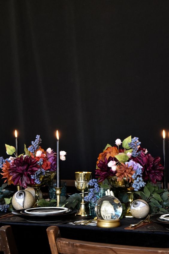 colorful Halloween arrangements of burgundy, blue, orange and purple blooms and greenery as centerpieces