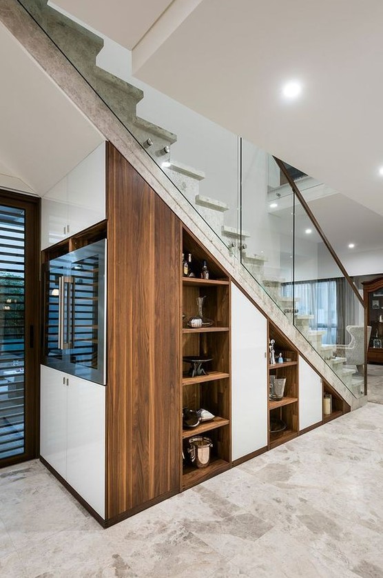 https://www.digsdigs.com/photos/2023/10/built-in-niche-shelves-a-wine-cooler-right-in-the-staircase-are-a-cool-idea.jpg