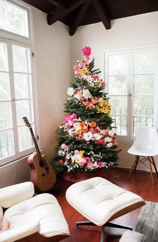 a Christmas tree decorated with blooms and lights is a unique boho chic idea to arise your inner flower child