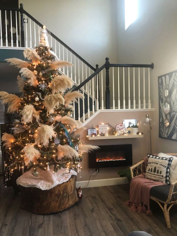a boho Christmas tree decorated with lights, pampas grass, stars and other ornaments is a cool solution