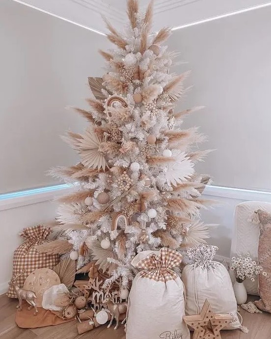 a boho neutral Christmas tree with pampas grass and dried fronds, white and neutral ornaments, some wooden beads