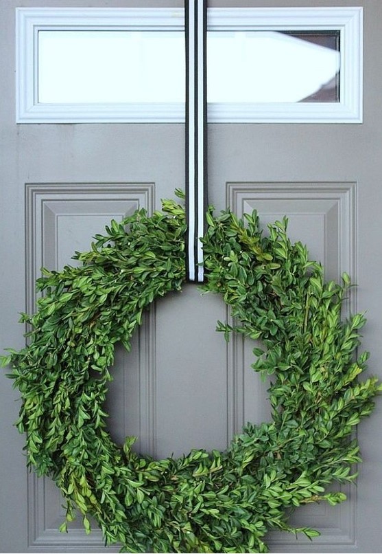 a catchy modern Christmas wreath of boxwood, with a striped ribbon will match many styles and decor themes