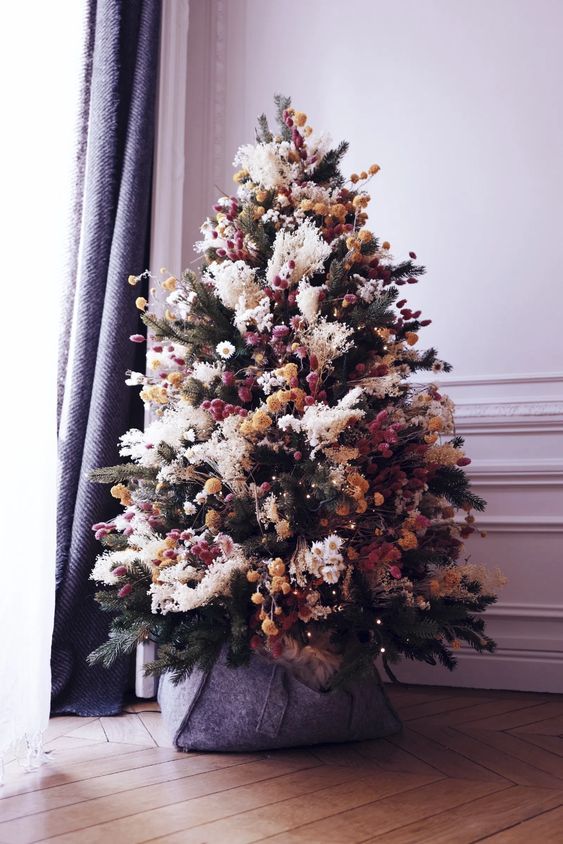 a creative boho Christmas tree with pampas grass, dried blooms and pompoms is a cool and bold solution