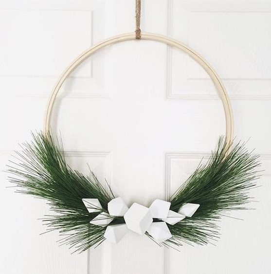 a minimalist Christmas wreath of an embroidery hoop, evergreens and white geometric ornaments is a cool idea