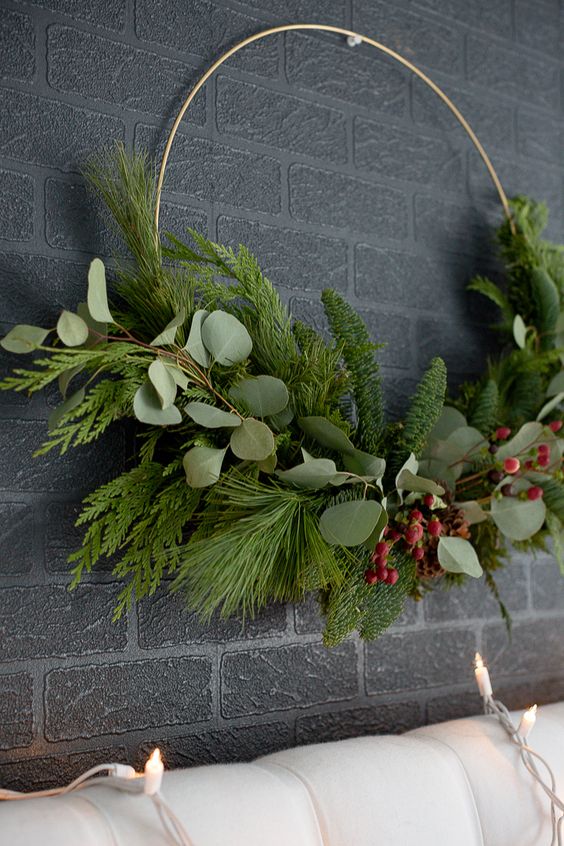 a modern Christmas wreath with greenery and evergreens and berries is a stylish and bright decoration for your front door