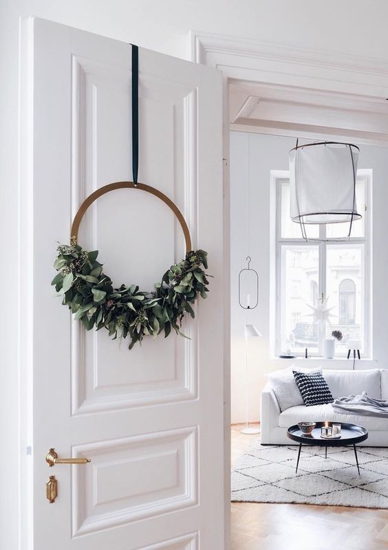 a modern Christmas wreath with lush greenery in the lower part is a cool and catchy idea that looks perfect
