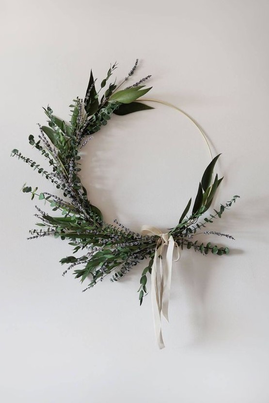 a modern and stylish Christmas wreath made with greenery and lavender, with a neutral ribbon bow is a catchy idea