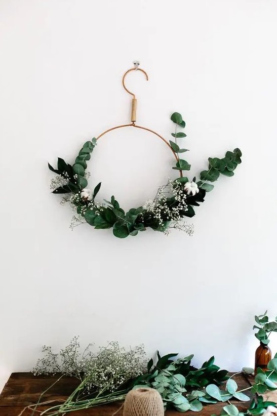 a modern copper wire Christmas wreath with eucalyptus, cotton and baby's breath is a great idea for a modern holiday space