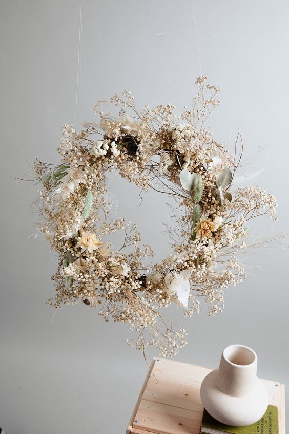 a modern ethereal Christmas wreath with dried blooms, grasses, berries and some leaves is a cool and catchy idea