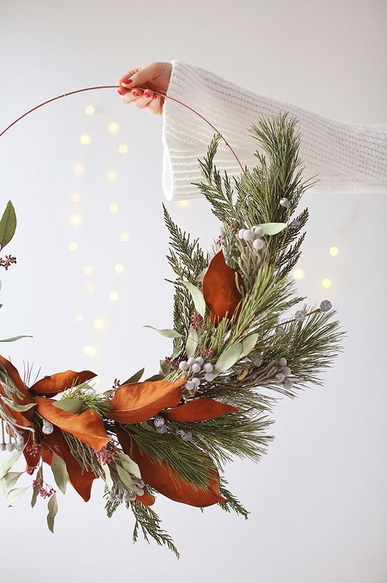 a modern holiday wreath with magnolia leaves, evergreens, berries and leaves is a cool idea for a modern space