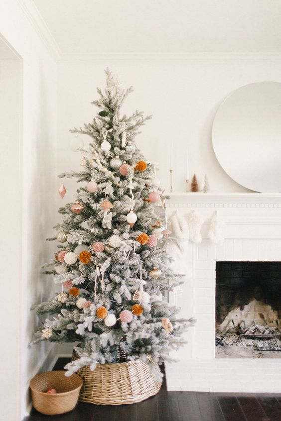 a simple and cute boho snowy Christmas tree with neutral ornaments and pompoms is a cool idea for a boho space